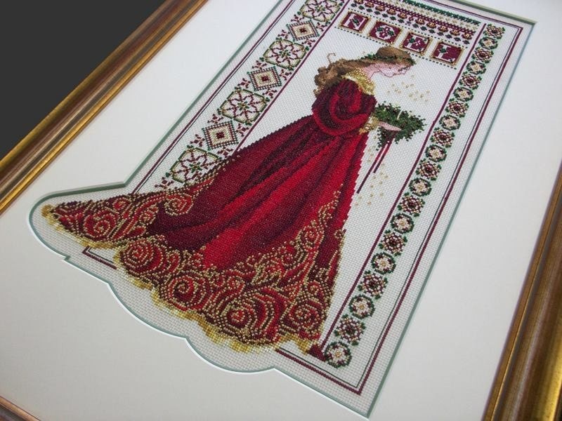 A cross stitch with bead work presented in a custom designed mount